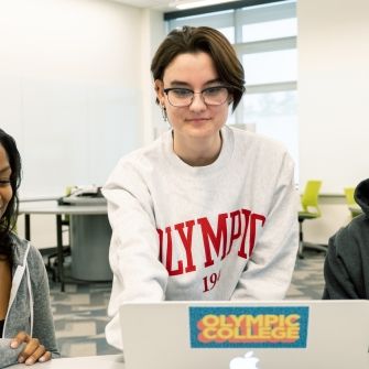 Three students at a laptop.